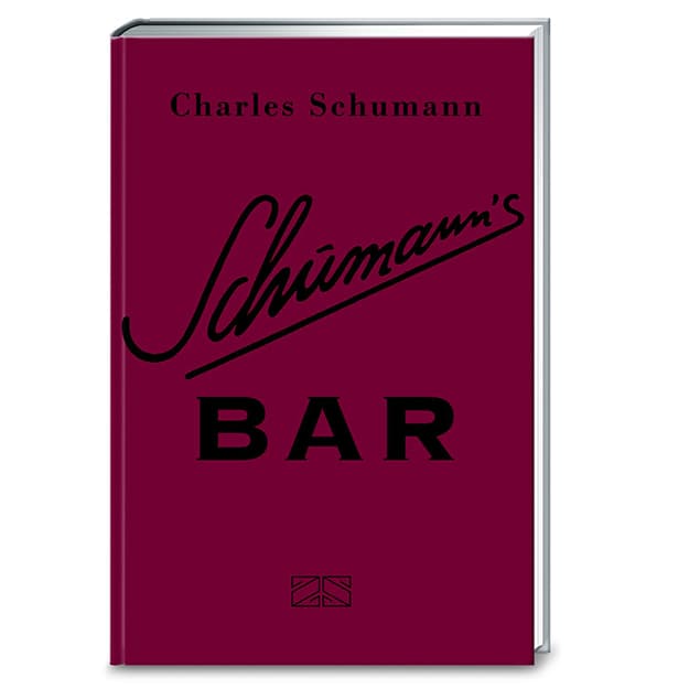 Buchcover mit dem Titel „Schumann’s Bar“ von Charles Schumann, mit kursiver Schrift auf dunkelrotem Hintergrund und einem kleinen Logo unten in der Mitte.