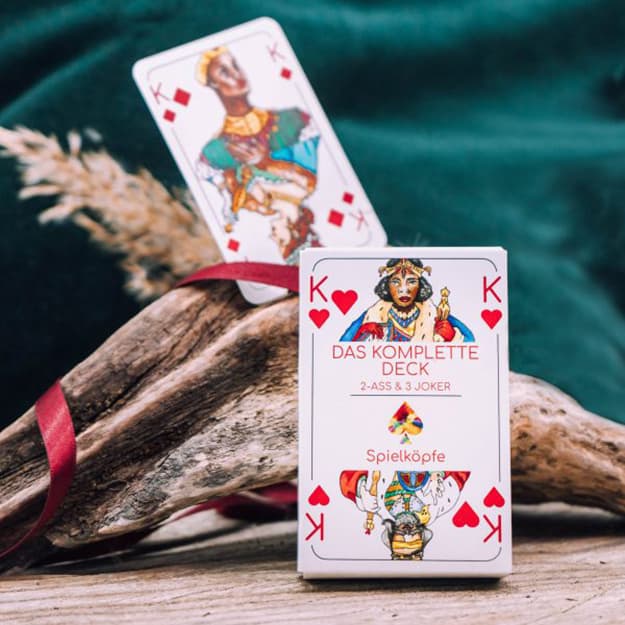 Ein Kartenspiel mit einem König, präsentiert vor Treibholz und einem grünen Textilhintergrund.