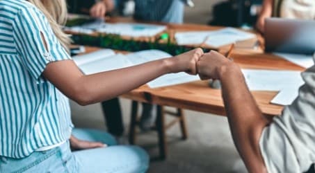 Zwei Kollegen drücken per Browfist ihre Zufriedenheit aus.