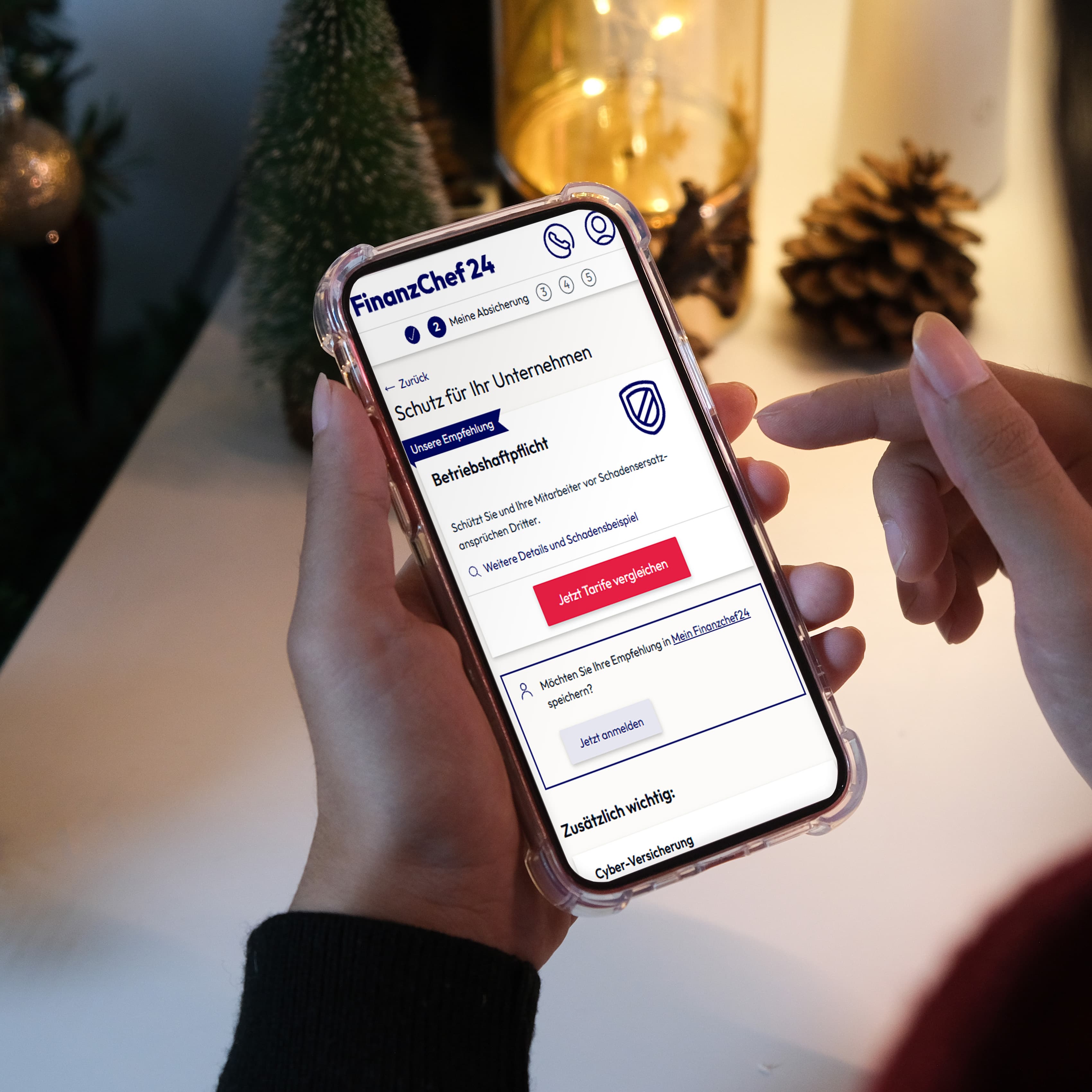 Person, die ein Smartphone mit einer geöffneten Finanz-App hält und auf einer Couch sitzt, im Hintergrund ist ein unscharfer Weihnachtsbaum zu sehen.