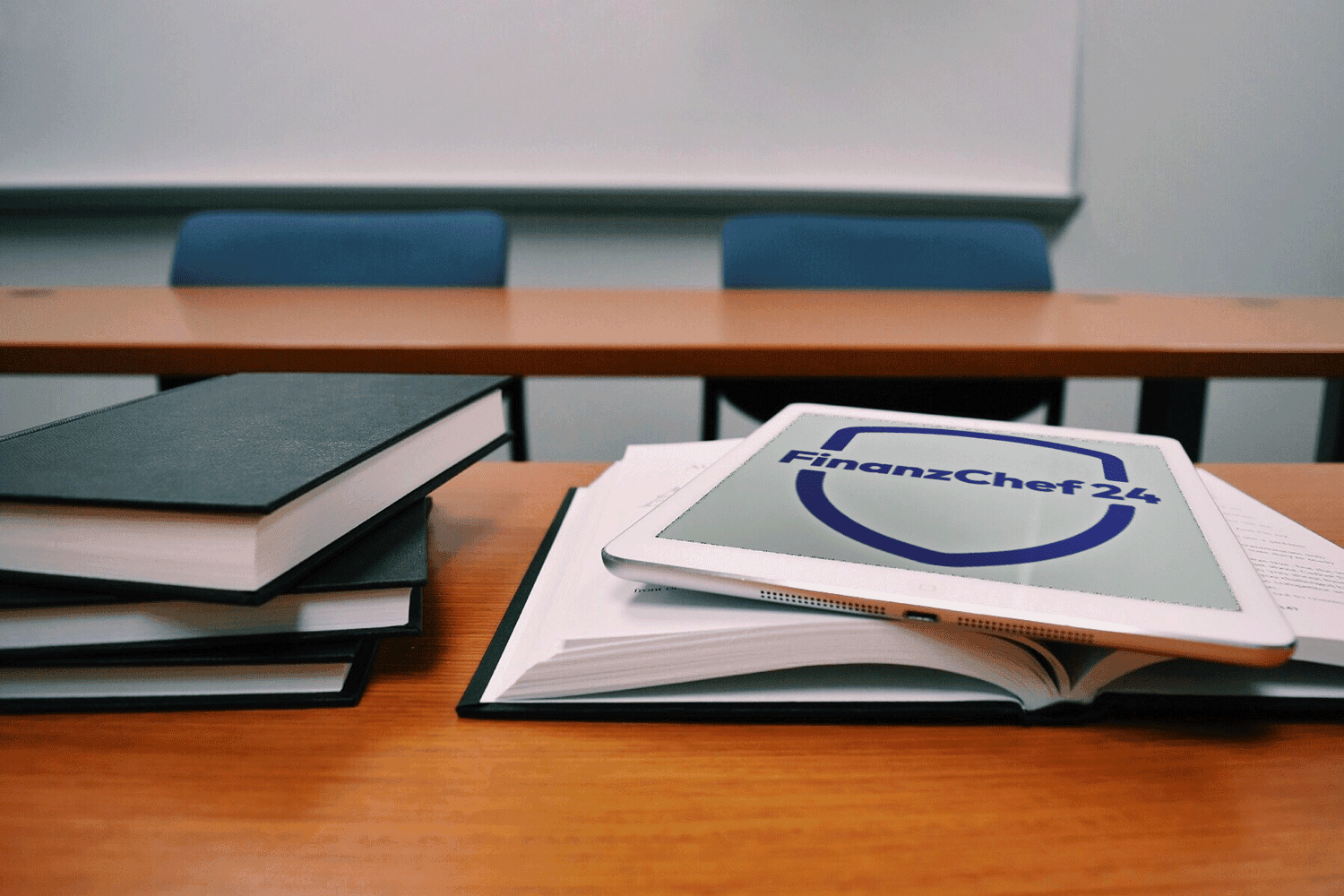 Tablet mit Versicherungsicon liegt auf Büchern