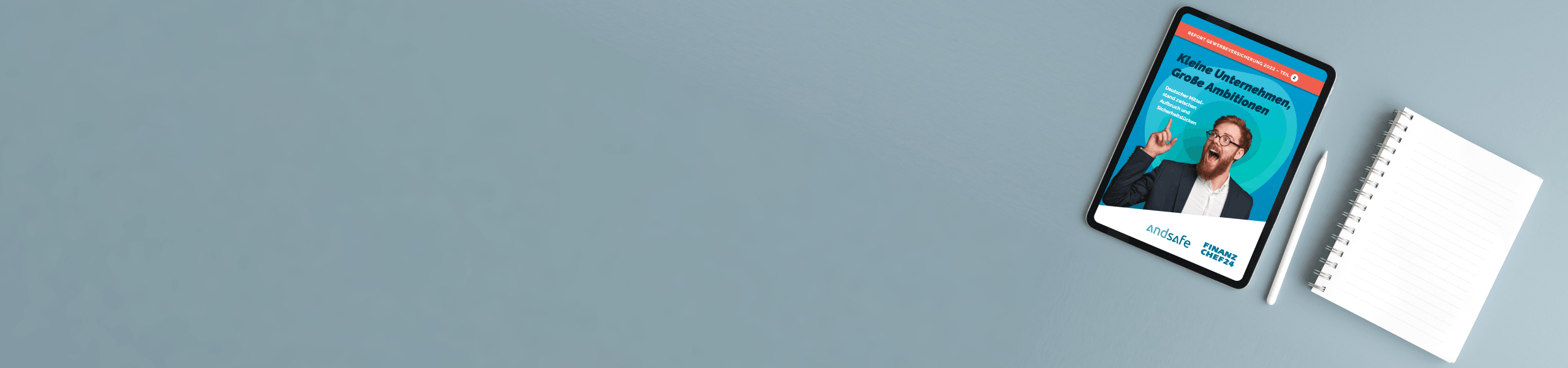 Tablet mit einem Nachrichtenartikel auf blauem Hintergrund neben einem Notizbuch und einem Stift.